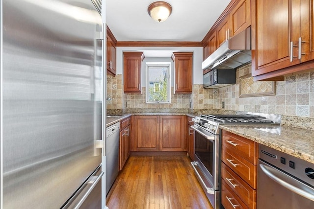 kitchen featuring brown cabinetry, appliances with stainless steel finishes, and under cabinet range hood