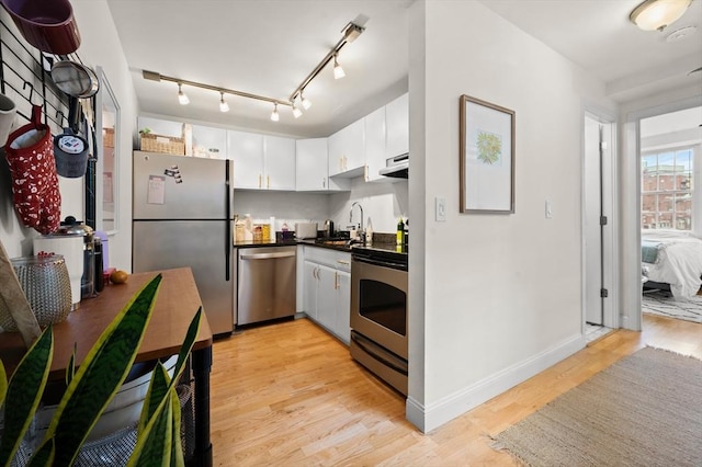 kitchen with sink, white cabinets, light hardwood / wood-style flooring, and stainless steel appliances