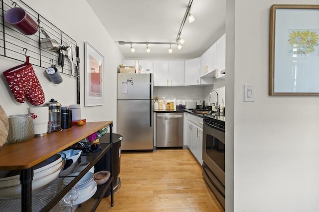 kitchen featuring light wood-type flooring, appliances with stainless steel finishes, white cabinets, and sink