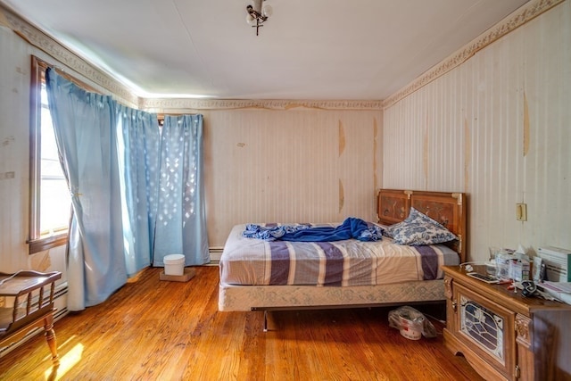 bedroom featuring a baseboard radiator and light hardwood / wood-style flooring