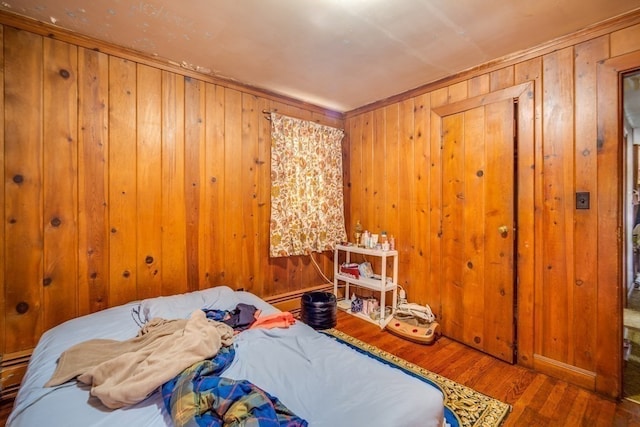 bedroom featuring wood walls and dark wood-type flooring