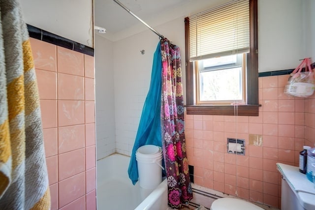 bathroom featuring shower / bath combination with curtain, toilet, and tile walls