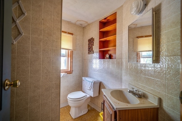 bathroom featuring tile walls, a healthy amount of sunlight, and vanity