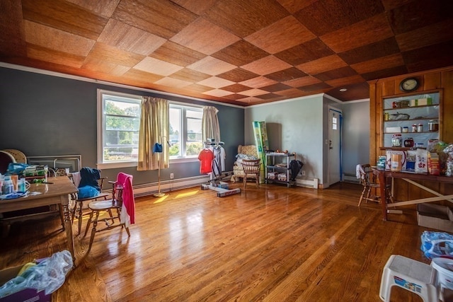 interior space with baseboard heating, ornamental molding, and wood-type flooring