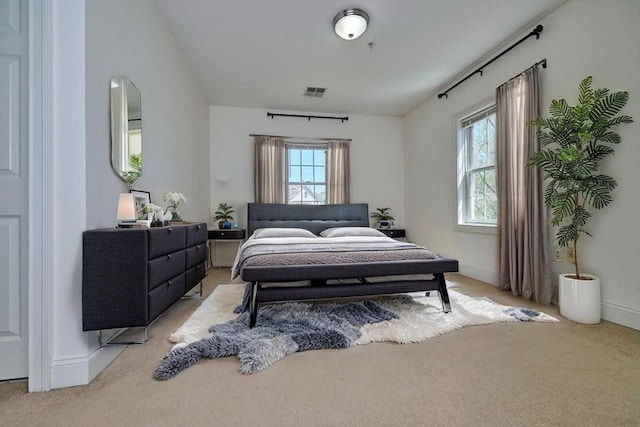 bedroom with baseboards, light carpet, and visible vents