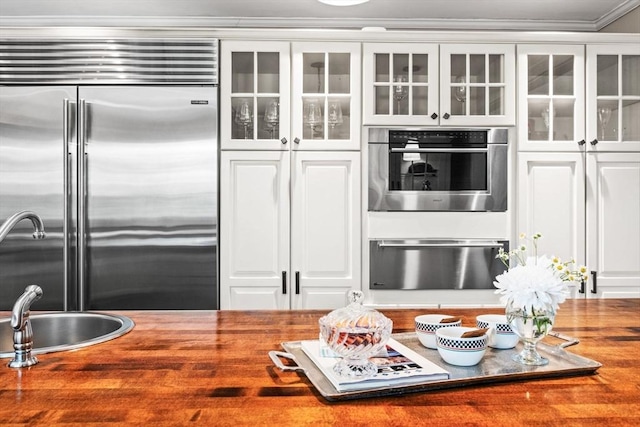 9 Wescott Rd, Andover, MA 01810 - kitchen featuring stainless steel built in fridge, wooden counters, glass insert cabinets, crown molding, and a warming drawer