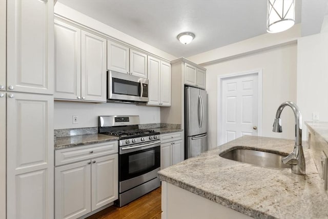 111-113 Pleasant St, Milton, MA 02186 - kitchen with stainless steel appliances, light stone counters, dark wood-style flooring, and hanging light fixtures
