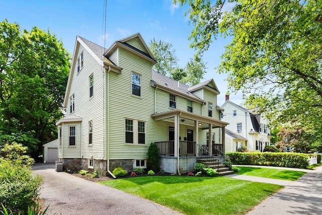 111-113 Pleasant St, Milton, MA 02186 - view of front of home with a porch, an outbuilding, a front yard, and a detached garage