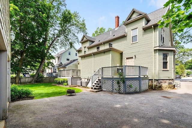 111-113 Pleasant St, Milton, MA 02186 - back of property with a deck, a chimney, an outdoor fire pit, and a shingled roof