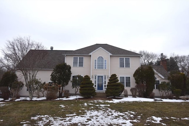 view of front of property with entry steps, a shingled roof, and a lawn