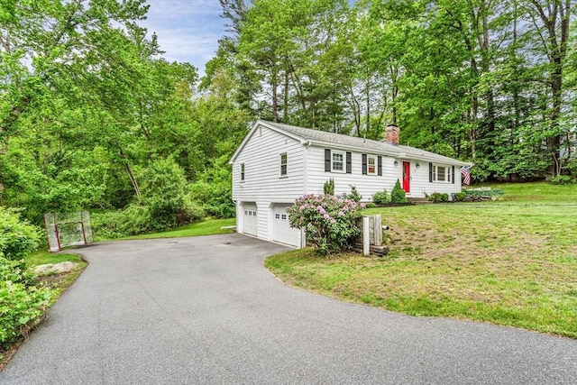 23 Cherokee Rd, Acton, MA 01720 - ranch-style home with a chimney, driveway, an attached garage, and a front yard