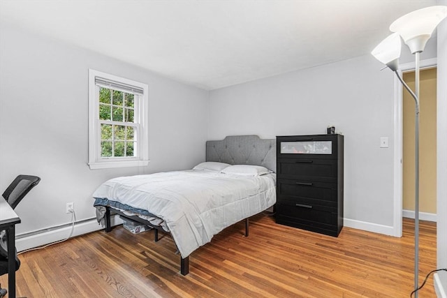 23 Cherokee Rd, Acton, MA 01720 - bedroom featuring baseboard heating, wood finished floors, and baseboards