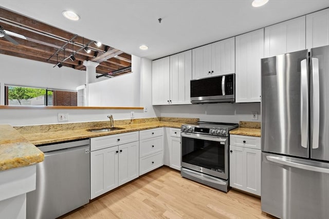 33 Sleeper St Unit 104, Boston, MA 02210 - kitchen featuring appliances with stainless steel finishes, a sink, white cabinetry, light wood-type flooring, and recessed lighting