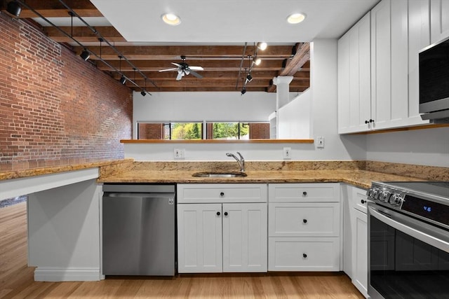 33 Sleeper St Unit 104, Boston, MA 02210 - kitchen featuring appliances with stainless steel finishes, a sink, ceiling fan, white cabinets, and light wood-type flooring