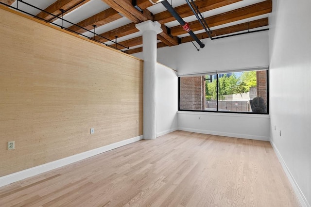 33 Sleeper St Unit 104, Boston, MA 02210 - unfurnished room with wood finished floors, baseboards, beam ceiling, and a high ceiling