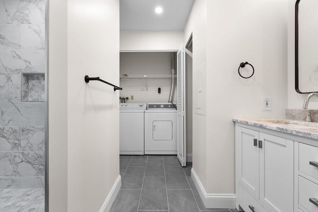 33 Sleeper St Unit 104, Boston, MA 02210 - full bathroom featuring baseboards, washer and clothes dryer, vanity, and tile patterned flooring