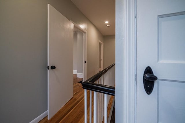 hall featuring wood finished floors, baseboards, and recessed lighting