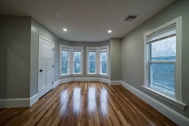 spare room featuring plenty of natural light, baseboards, dark wood finished floors, and recessed lighting