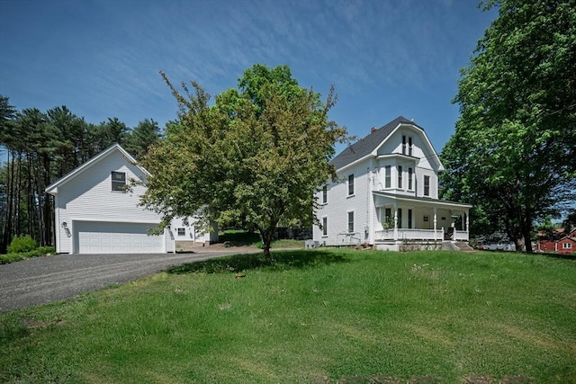 view of front of home featuring covered porch, a front lawn, and asphalt driveway