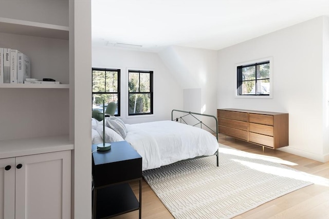 bedroom with multiple windows and light wood-type flooring