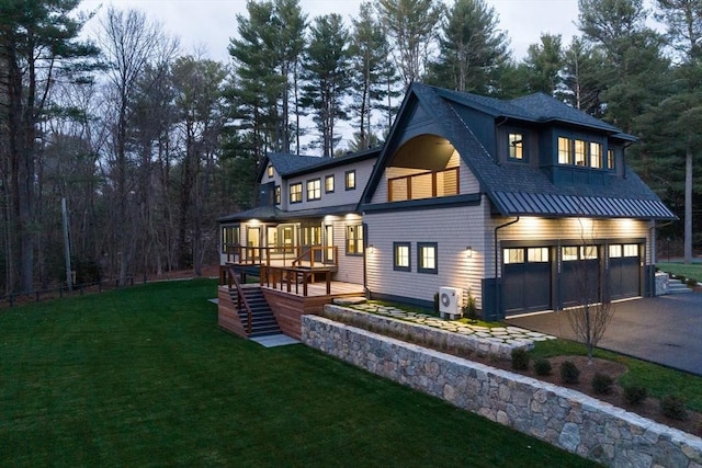 rear view of property featuring a garage, a sunroom, and a yard