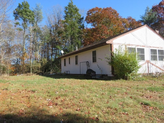 view of side of home with a yard and stucco siding