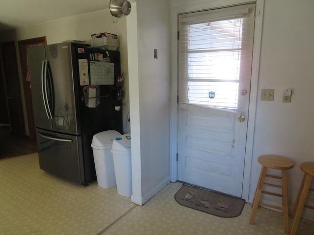 doorway with baseboards and light floors