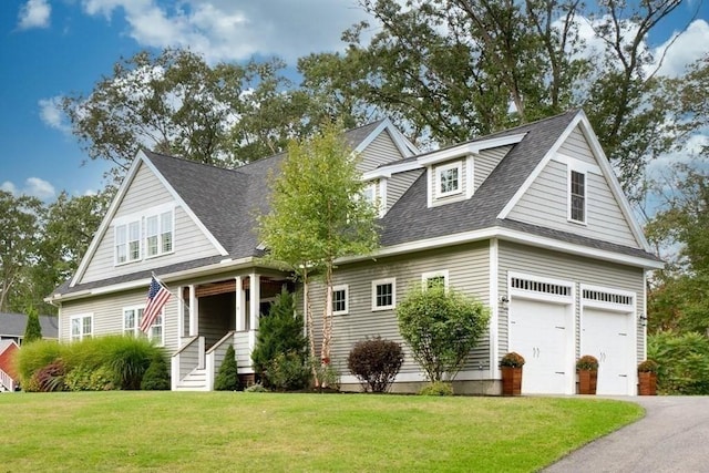 view of front of property featuring an attached garage, driveway, a shingled roof, and a front yard