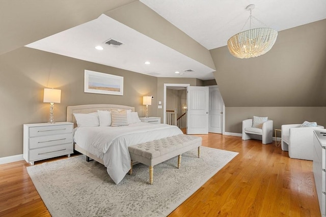 bedroom with light wood finished floors, visible vents, baseboards, lofted ceiling, and recessed lighting