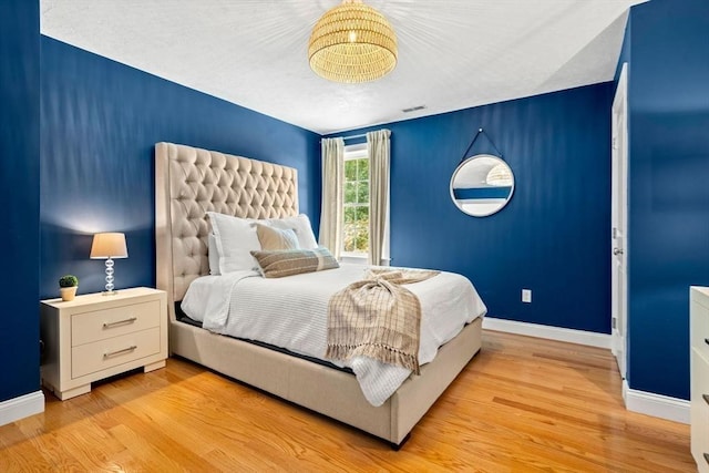 bedroom with visible vents, baseboards, and light wood-style floors