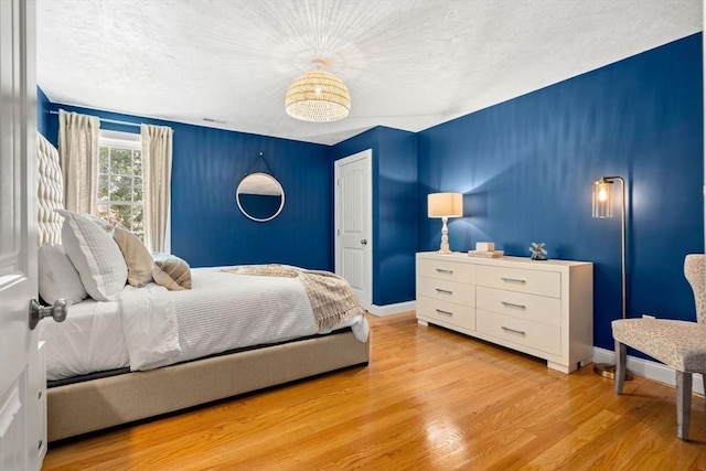 bedroom featuring light wood finished floors and baseboards