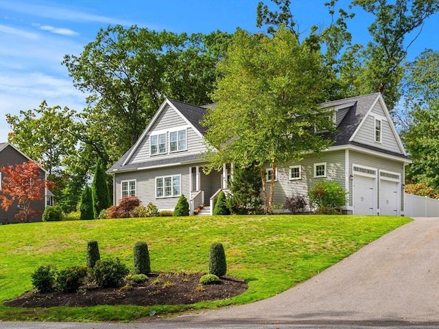 view of front of property featuring a front yard, fence, and driveway