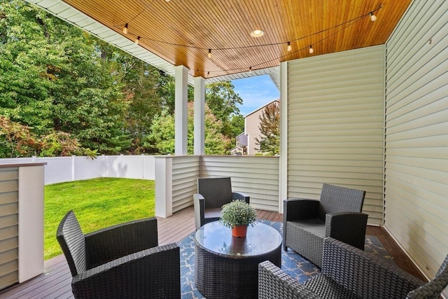 wooden terrace with a yard and fence