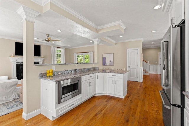 kitchen with white cabinets, stainless steel appliances, and decorative columns
