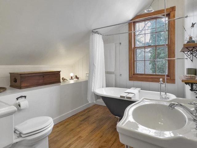 full bathroom featuring sink, hardwood / wood-style floors, plus walk in shower, vaulted ceiling, and toilet