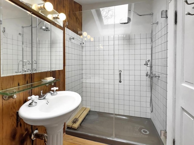 bathroom featuring a skylight and a shower with door