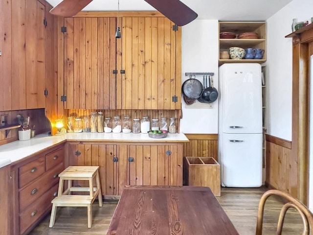 kitchen with light wood-type flooring and wood walls