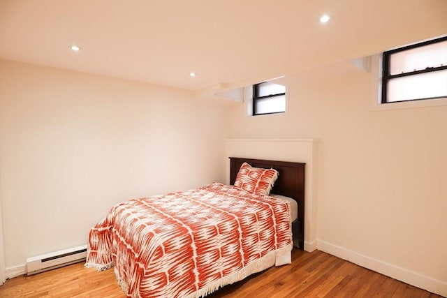 bedroom featuring wood-type flooring and baseboard heating