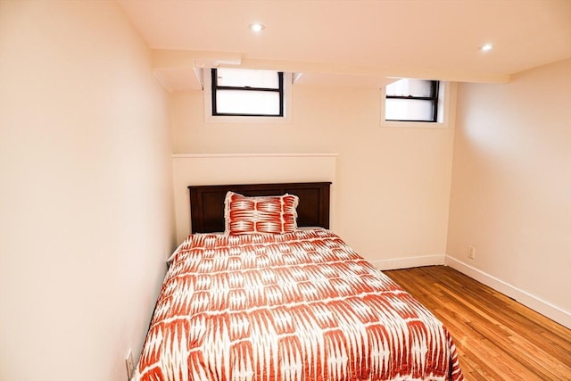 unfurnished bedroom with multiple windows and wood-type flooring