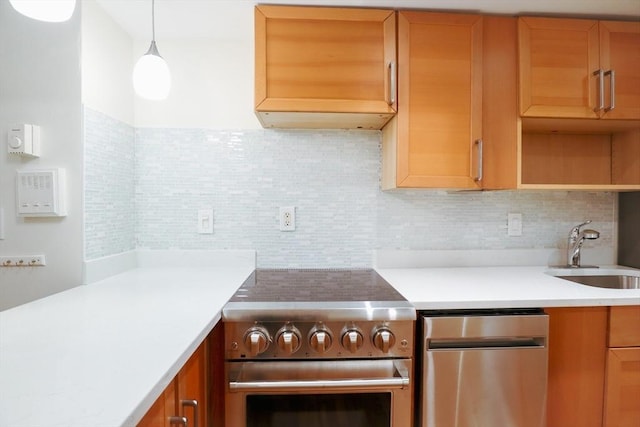 kitchen featuring high end stove, backsplash, sink, and decorative light fixtures