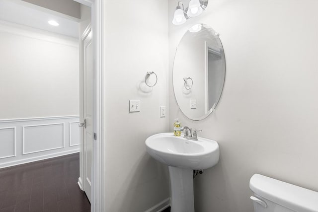 184 Stonehaven Dr, Weymouth, MA 02190 - half bathroom featuring toilet, wood finished floors, and a wainscoted wall