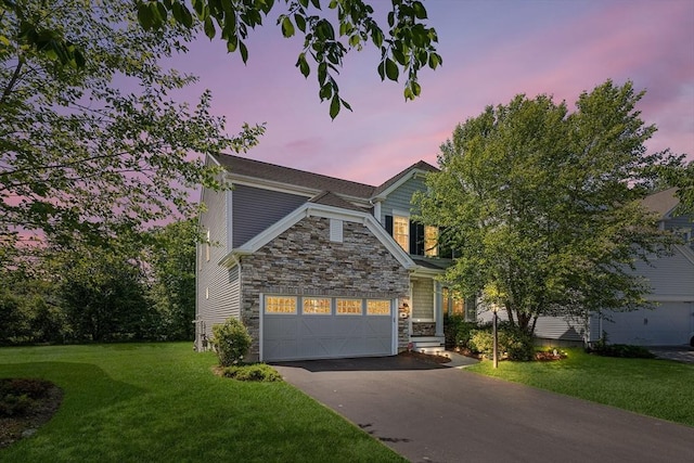 184 Stonehaven Dr, Weymouth, MA 02190 - view of front of house with stone siding, asphalt driveway, a garage, and a front yard