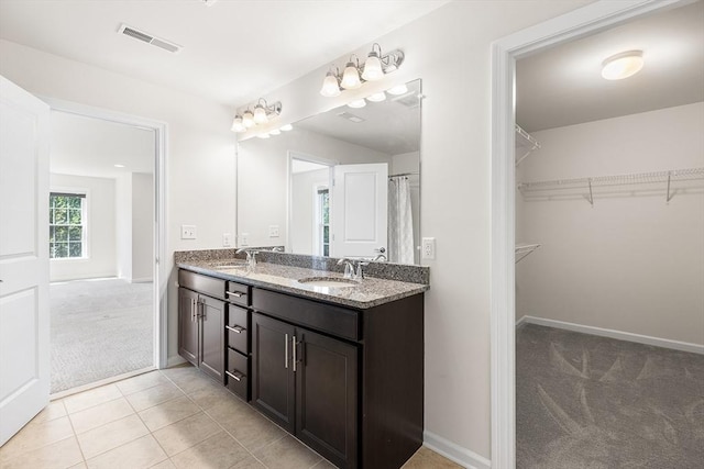 184 Stonehaven Dr, Weymouth, MA 02190 - bathroom with double vanity, a spacious closet, baseboards, and tile patterned flooring