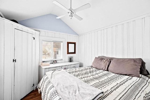 bedroom with dark wood-style flooring, vaulted ceiling, and ceiling fan