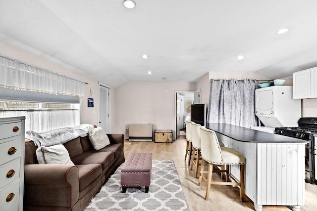 living area with vaulted ceiling, light wood-type flooring, and recessed lighting