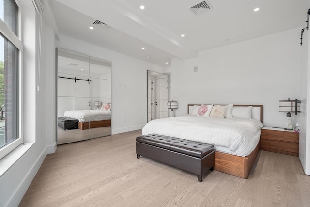 69 Walnut St Unit 4, Brookline, MA 02445 - bedroom with a barn door, light wood-style floors, recessed lighting, and baseboards