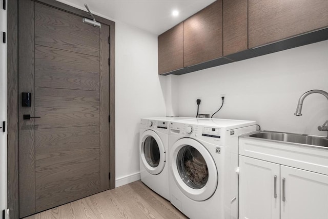 69 Walnut St Unit 4, Brookline, MA 02445 - washroom with cabinet space, washing machine and clothes dryer, and light wood-style floors