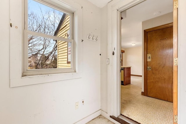 entryway featuring light floors and baseboards