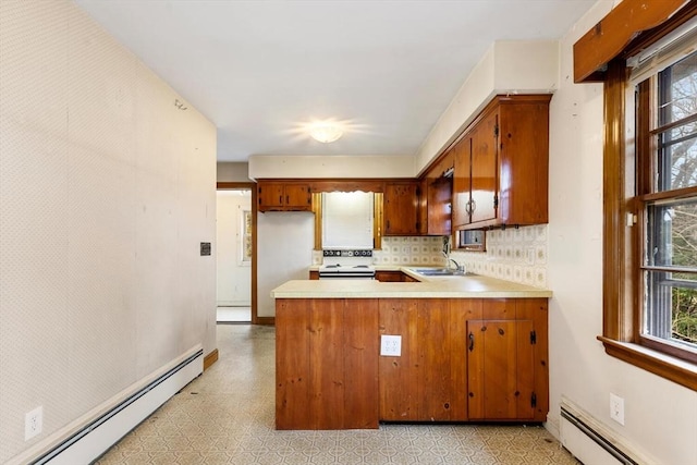 kitchen with a baseboard heating unit, light floors, brown cabinetry, and light countertops