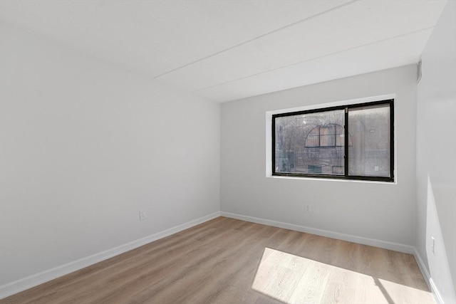 empty room featuring baseboards and wood finished floors